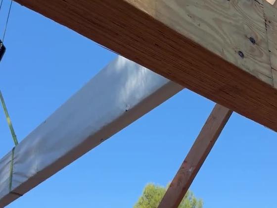 Crane flying a glulam beam onto a framed structure in Ventura