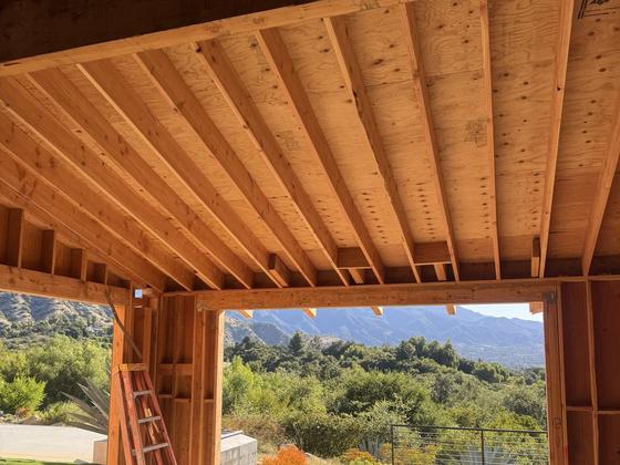 Exposed rafter and beam ceiling framing with mountain views beyond