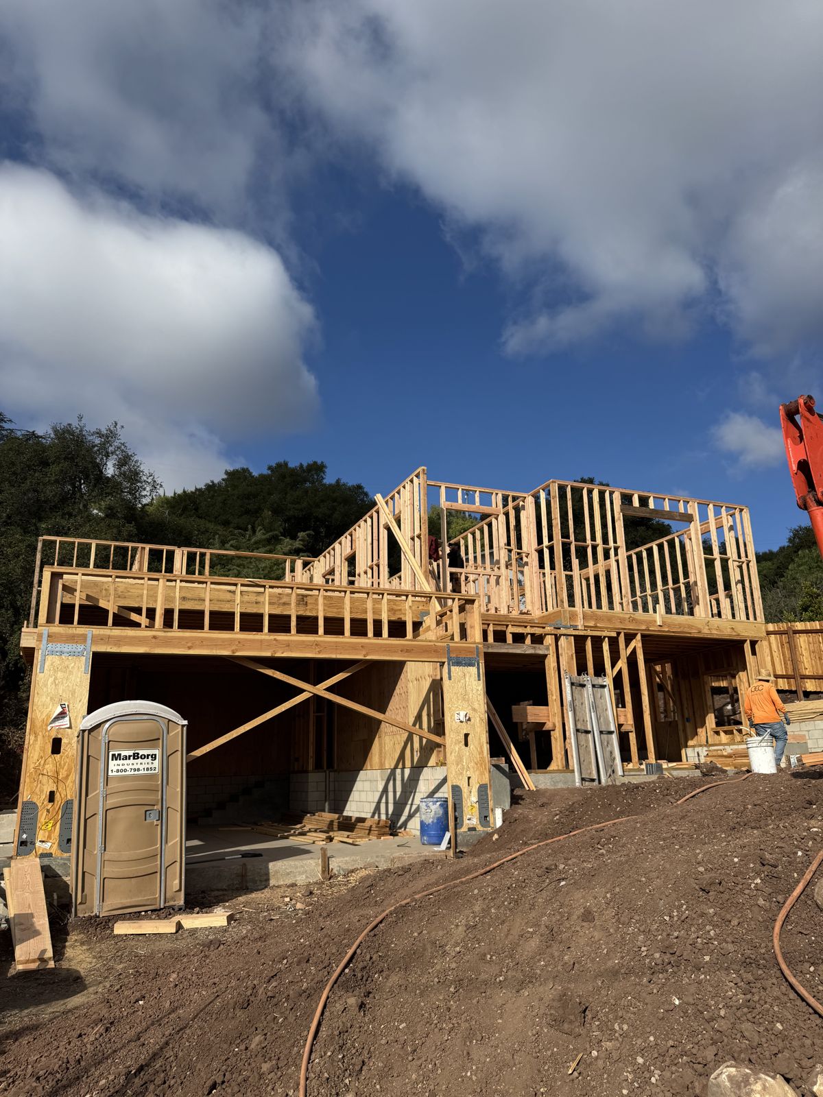 Custom home frame in progress on a hillside lot