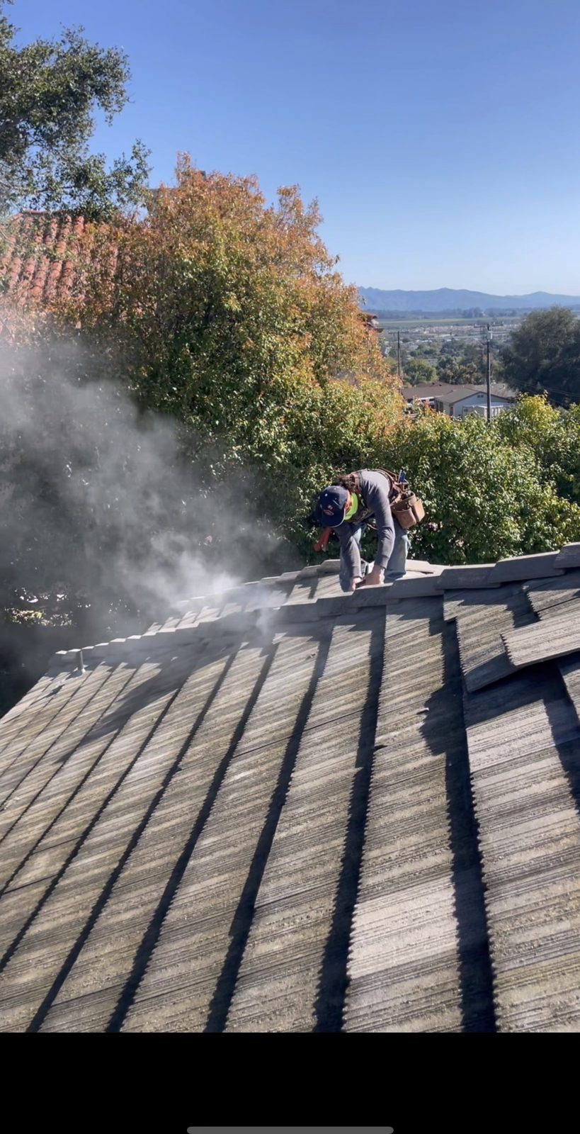 NRG crew repairing a tile roof on a hillside home